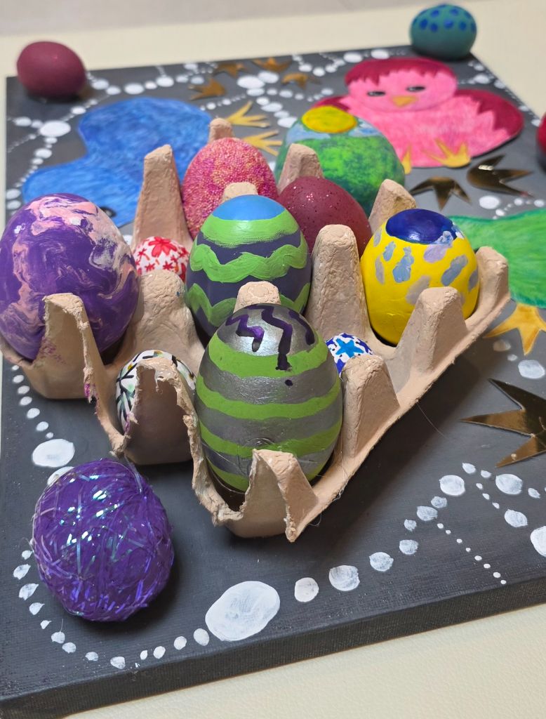 Overhead view of the mixed-media piece, laying out the full grid of eggs and cut-out chicks flat.